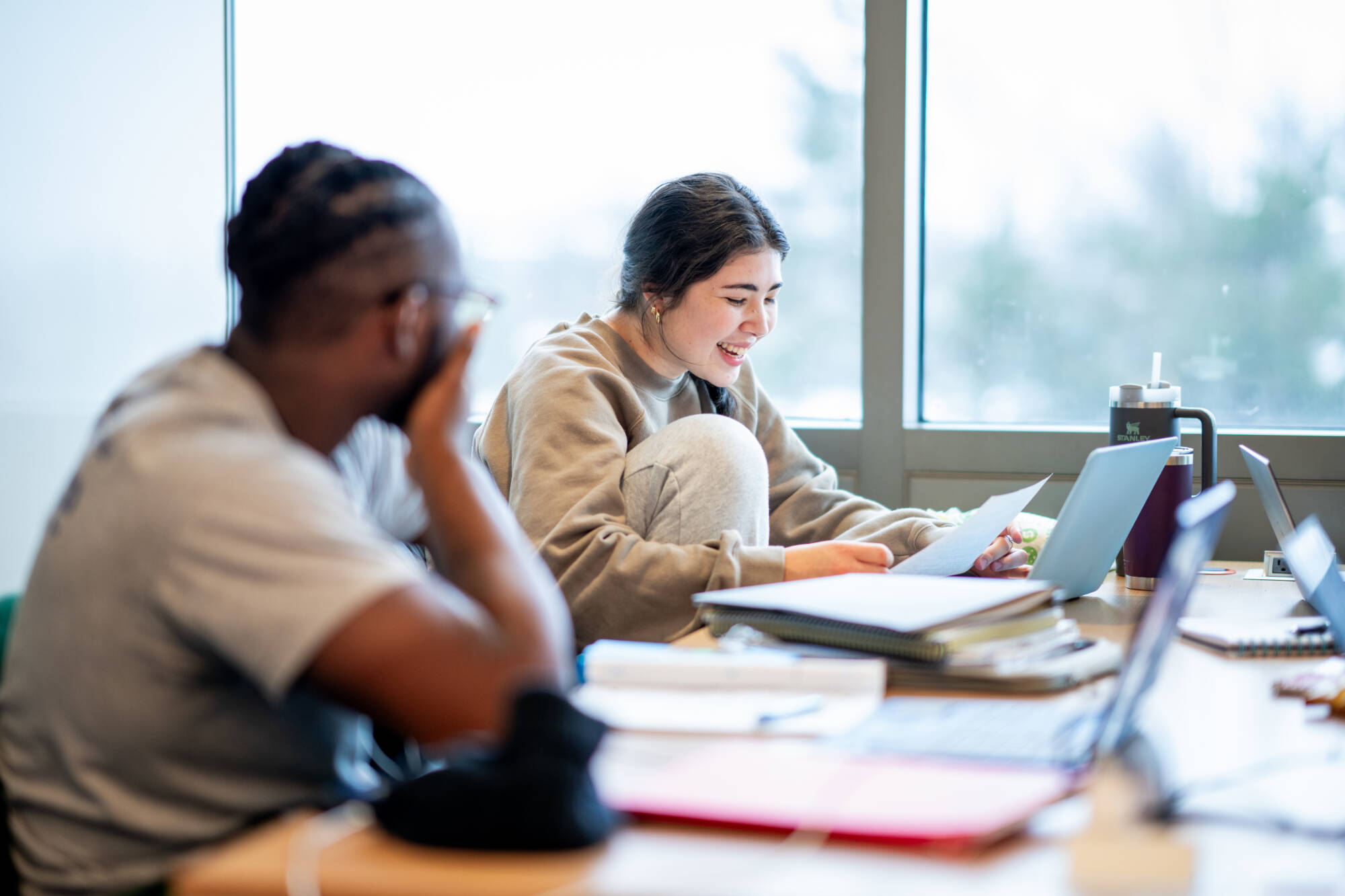 Junior Biomedical Science/Economics major Grace Flanders laughes with friends during a study session together in the Mary Idema Pew Library, January 25, 2024. (Photo by Amanda Pitts)